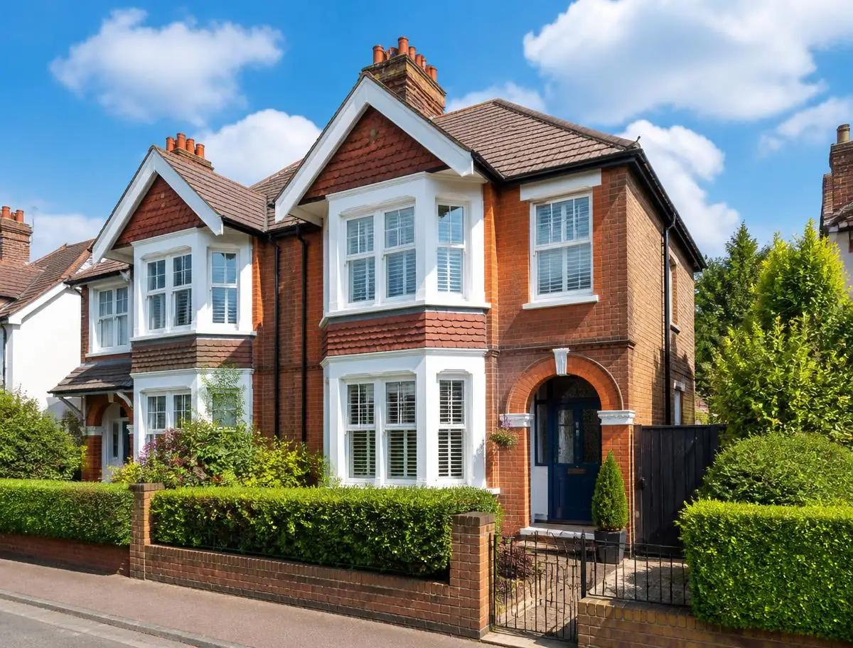 Red brick British semi-detached house with bay windows